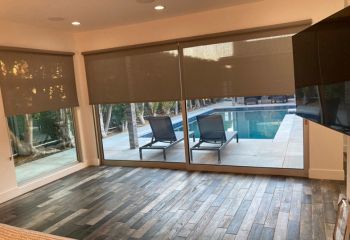 Simi Valley living room featuring custom screen shades for roller doors in a half-lowered position, balancing outdoor light and privacy.