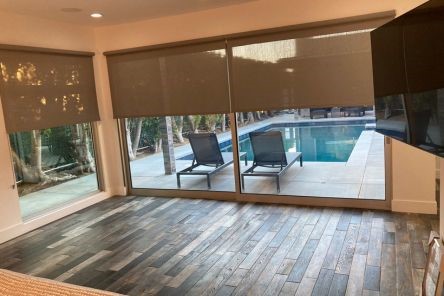 Simi Valley living room featuring custom screen shades for roller doors in a half-lowered position, balancing outdoor light and privacy.